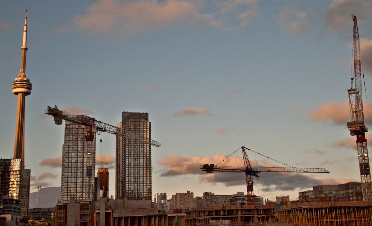 CN tower and cranes at sunset.