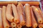 Fresh churros in tray.