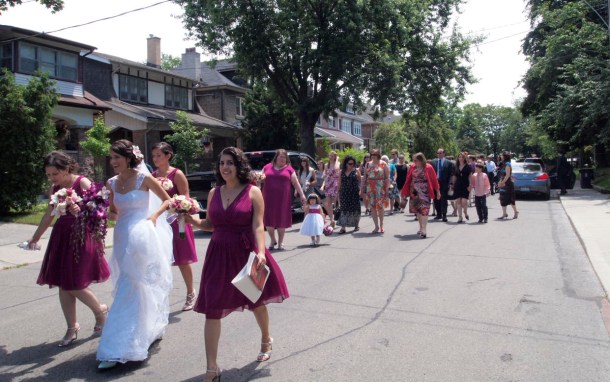 Bridal party walking down the middle of the street.