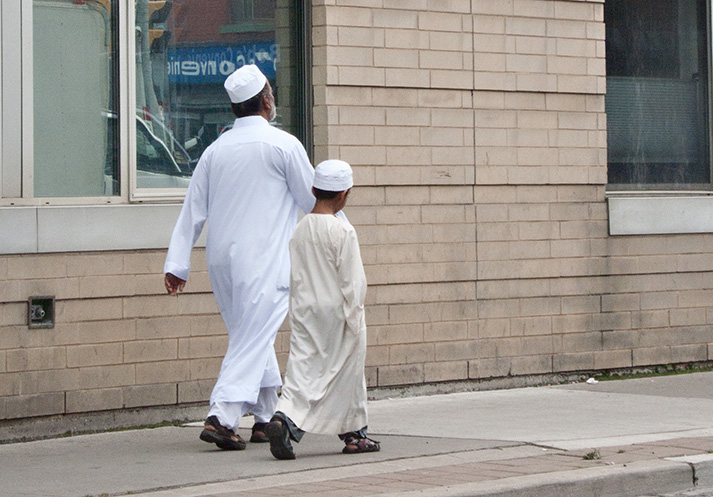 Father and son walking on sidewalk.