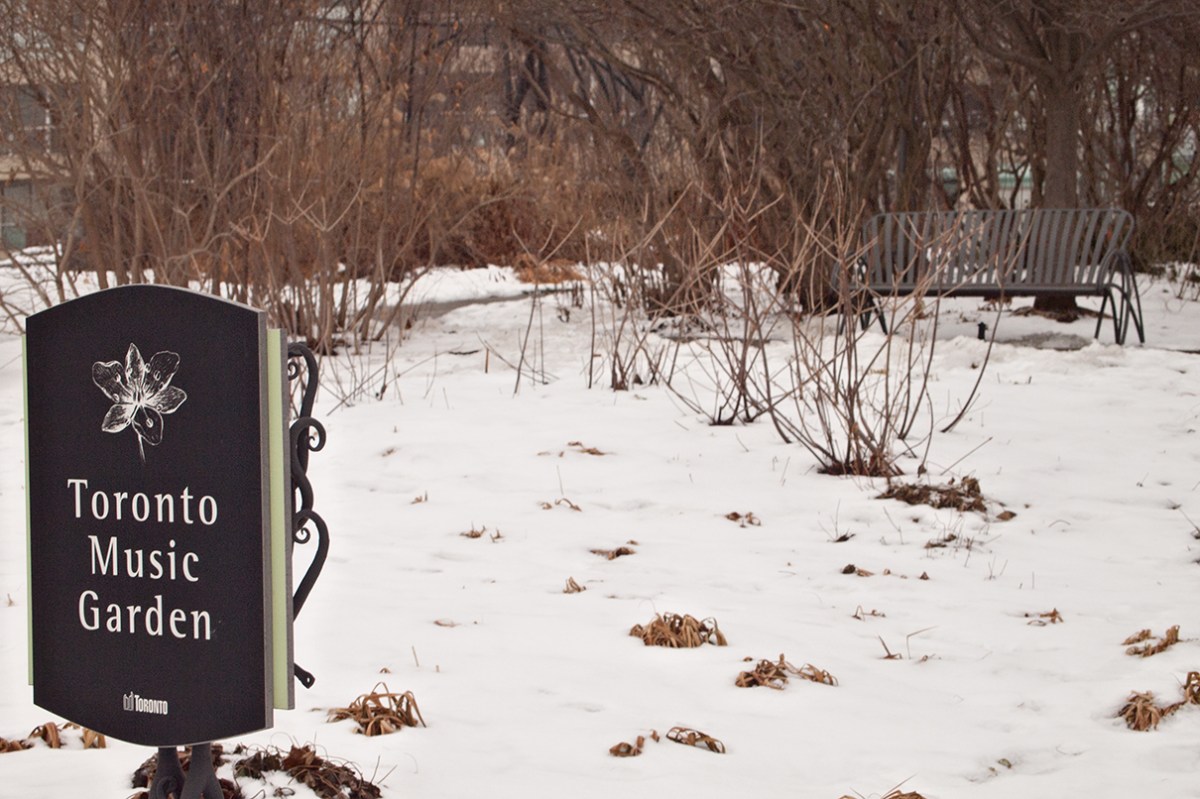 Music garden sign with bench in background.