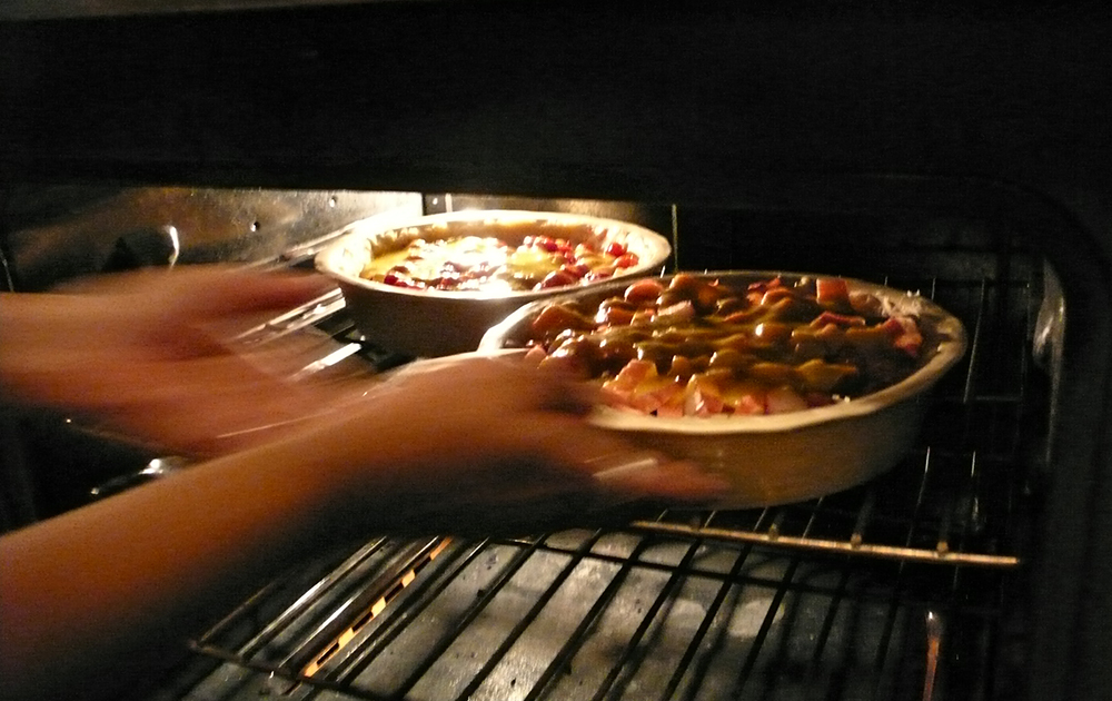 Placing pies in oven to bake.