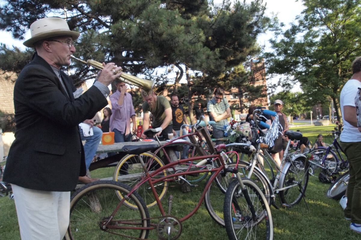 Trumpeter calls bike riders.