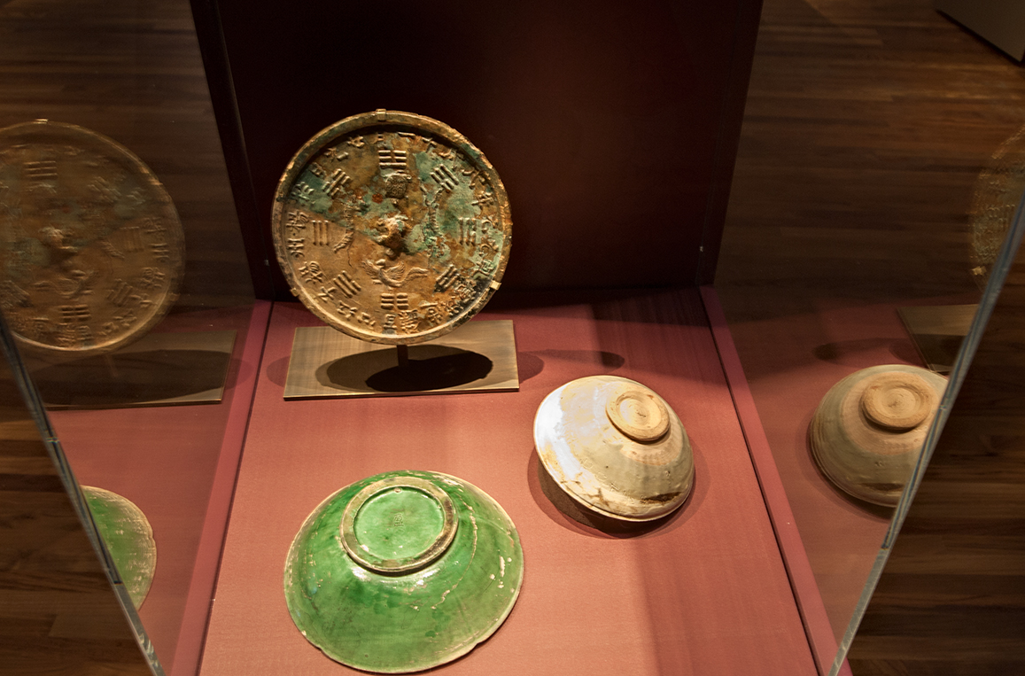 Bowls and mirror in vitrine.