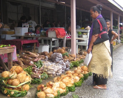 Woman and coconuts at market in Tonga.