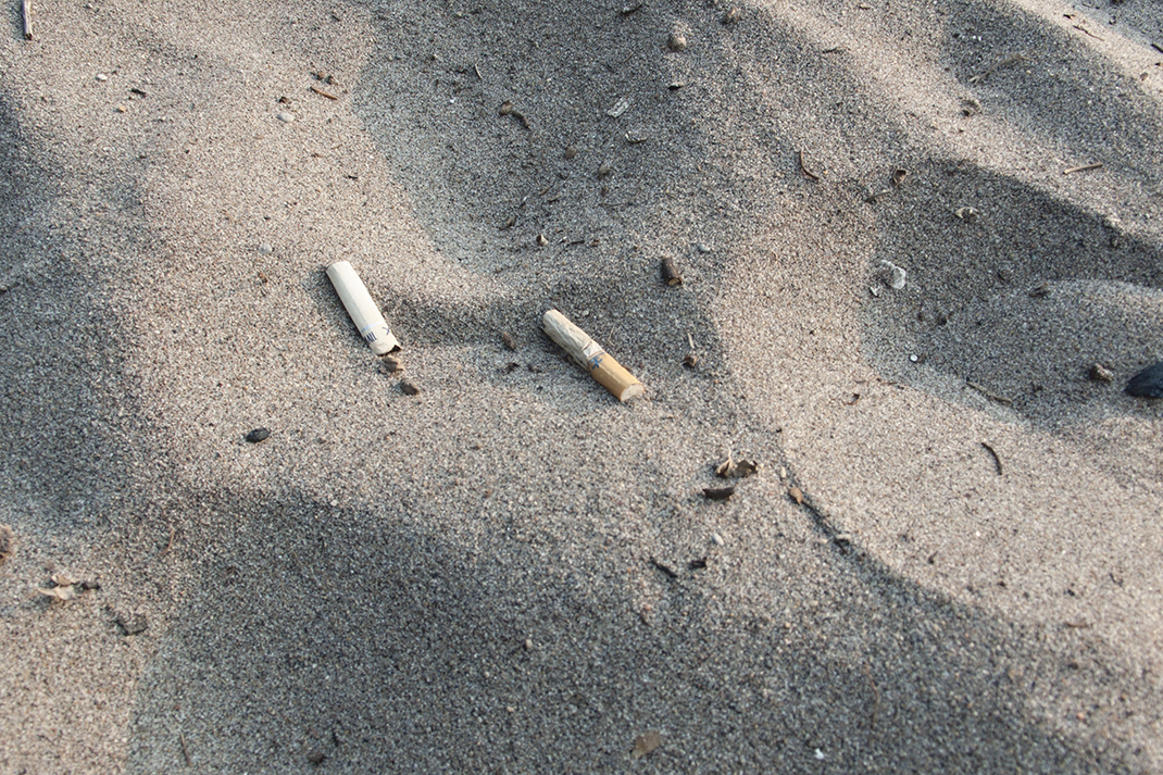 Cigarette butts in sand at Hanlan's beach.