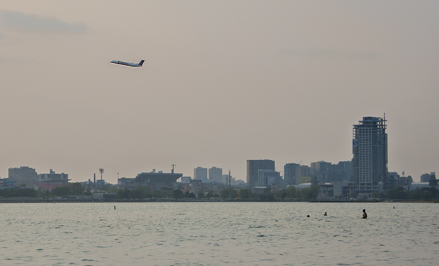 Plane taking off over swimmers at Hanlan's.