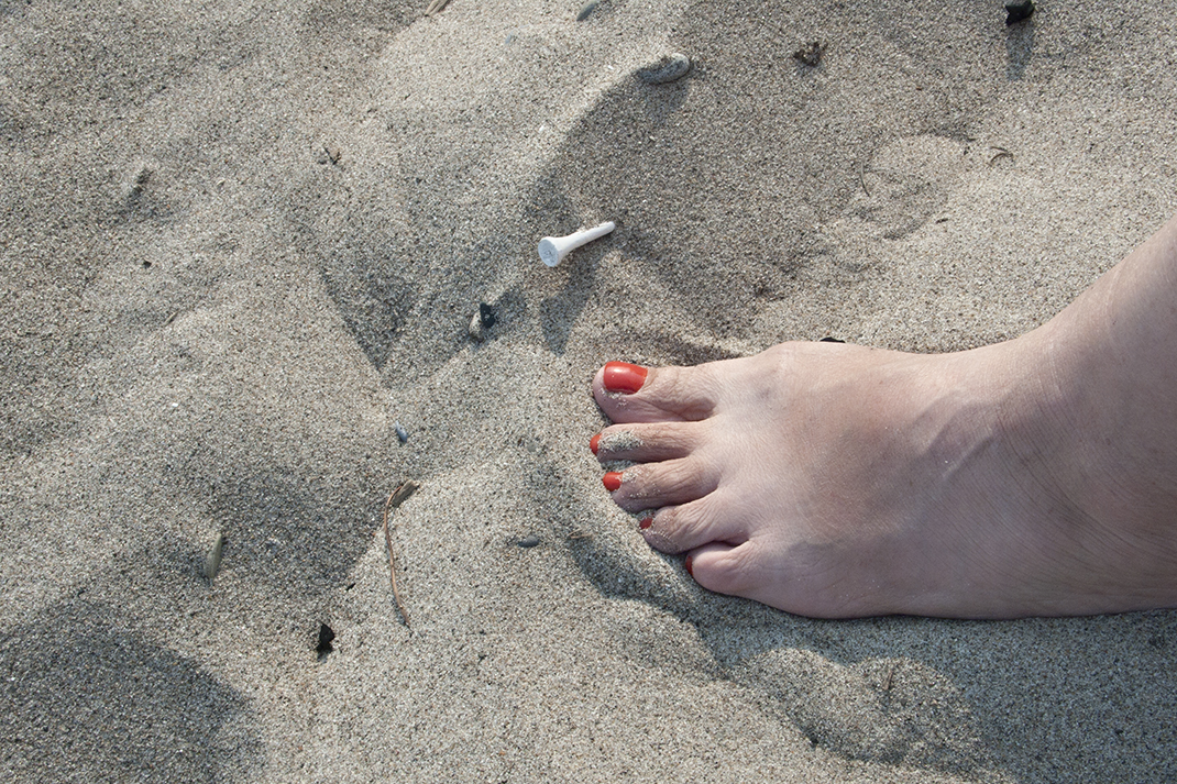 Sand with golf tee imbedded at Gibraltar Point beach.
