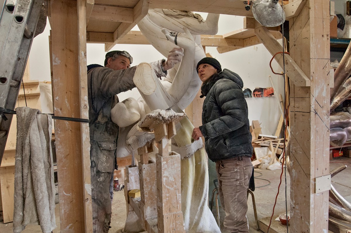 Sculptor showing assistant a point.