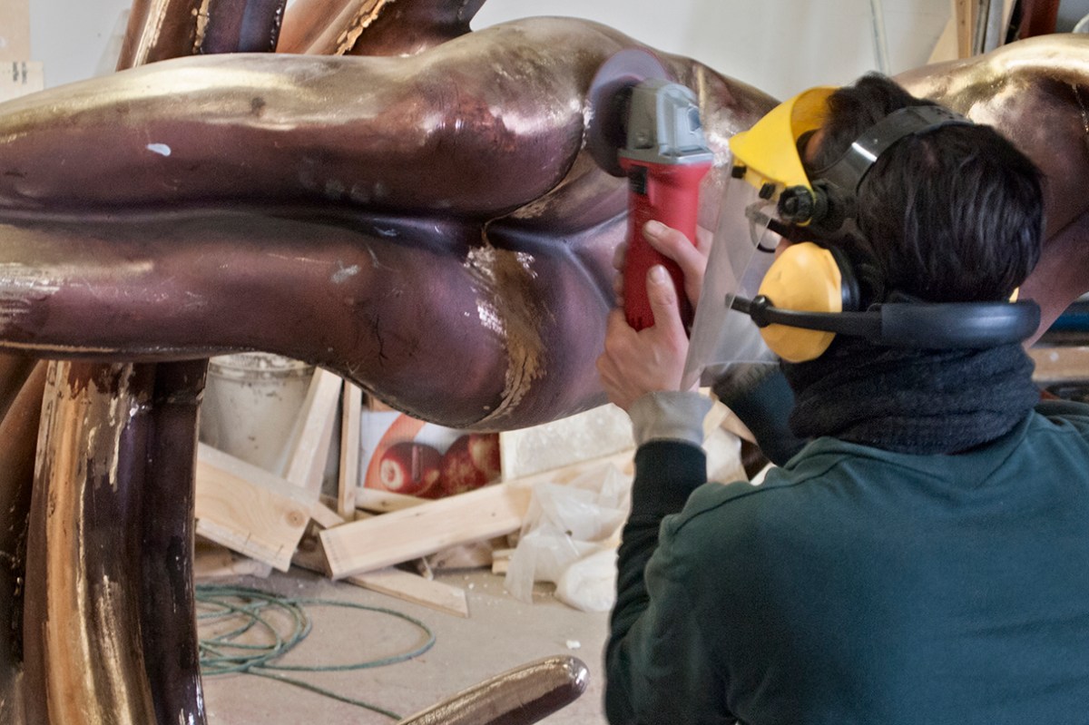 Grinding welds on sculpture.
